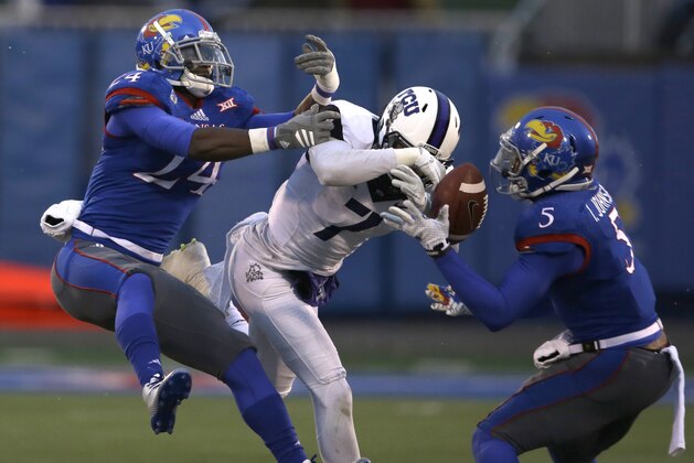 Kansas cornerback JaCorey Shepherd (24) and Kansas safety Isaiah Johnson (5) prevent a catch by TCU wide receiver Kolby Listenbee (7) during the second half of an NCAA college football game in Lawrence, Kan., Saturday, Nov. 15, 2014. TCU defeated Kansas 34-30. (AP Photo/Orlin Wagner)