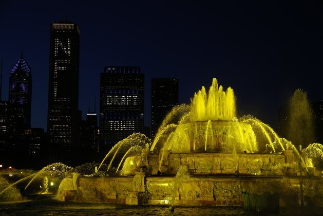 Buckingham Fountain in Chicago's Grant Park is illuminated yellow as the New Orleans Saints announce their draft picks in the 2015 NFL Football Draft Thursday, April 30, 2015, in Chicago. (AP Photo/Andrew A. Nelles)