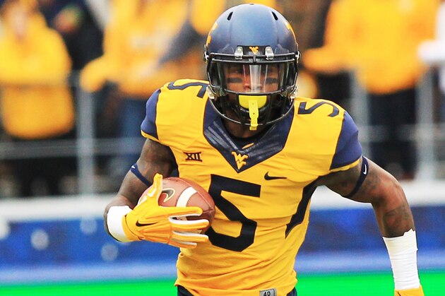 West Virginia's Mario Alford (5) carries the ball during the second quarter of an NCAA college football game against Kansas in Morgantown, W.Va., Saturday, Oct. 4, 2014. West Virginia won 33-14. (AP Photo/Chris Jackson)