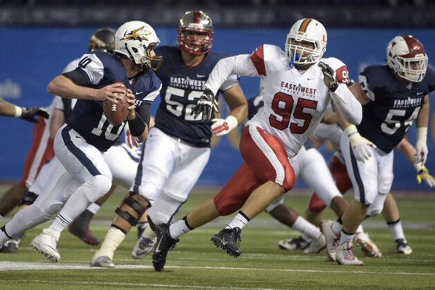 West quarterback Taylor Kelly (10), of Arizona State, scrambles for yardage in front of East defensive lineman Anthony Chickillo (95), of Miami, during the second half of the East-West Shrine college football game in St. Petersburg, Fla., Saturday, Jan. 17, 2015. The East won 19-3.(AP Photo/Phelan M. Ebenhack)