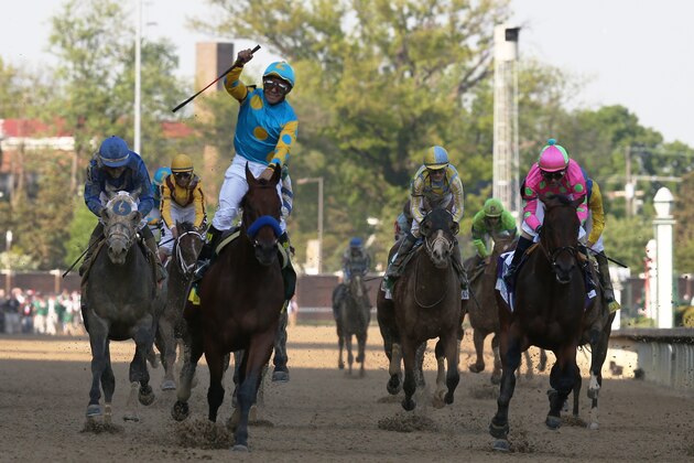 LOUISVILLE, KY - MAY 02:  Jockey Victor Espinoza celebrates as he guides American Pharoah #18 after crossing the finish line to win the 141st running of the Kentucky Derby at Churchill Downs on May 2, 2015 in Louisville, Kentucky.  (Photo by Chris Graythen/Getty Images)