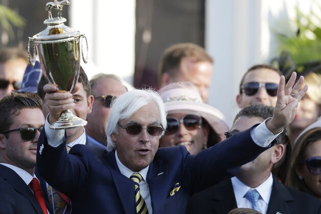 Trainer Bob Baffert holds up the winning trophy after the 141st running of the Kentucky Derby horse race at Churchill Downs Saturday, May 2, 2015, in Louisville, Ky. (AP Photo/Brynn Anderson)