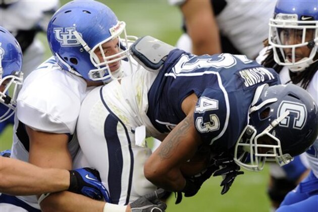 Buffalo's Kristjan Sokoli, left, tackles Connecticut's Lyle McCombs during the first half of Connecticut's 24-17 victory in their NCAA football game in East Hartford, Conn., on Saturday, Sept. 29, 2012. (AP Photo/Fred Beckham)