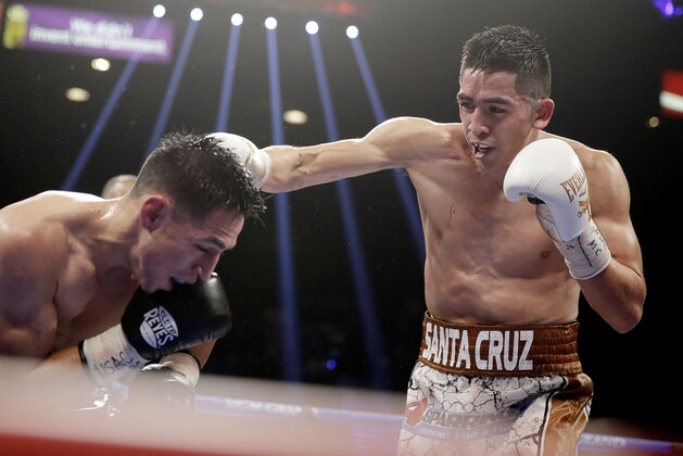 Leo Santa Cruz, right, punches Jesus Ruiz during their WBC super bantamweight championship boxing bout Saturday, Jan. 17, 2015, in Las Vegas. Santa Cruz won the fight when it was stopped in the eighth round. (AP Photo/Isaac Brekken)