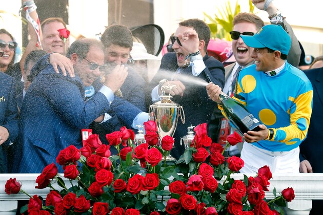 LOUISVILLE, KY - MAY 02:  Jockey Victor Espinoza of American Pharoah #18 celebrates by spraying owner Ahmed Zayat with champagne in winners circle after winning the 141st running of the Kentucky Derby at Churchill Downs on May 2, 2015 in Louisville, Kentucky.  (Photo by Rob Carr/Getty Images)