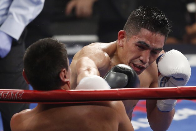 Leo Santa Cruz, of Rosemead, Calif., right, hits Jose Cayetano, of Mexico, during their featherweight fight on Saturday, May 2, 2015 in Las Vegas. (AP Photo/Eric Jamison)