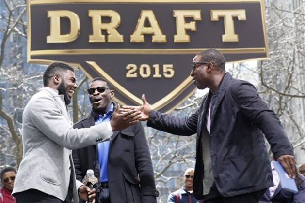 Alabama's Landon Collins, left, is greeted by Michael Irvin, center, and Cris Carter during introductions at a pre-draft rally of 2015 NFL Draft prospects, and various league legends at Pioneer Court, Wednesday, April 29, 2015, in Chicago. (AP Photo/Charles Rex Arbogast)