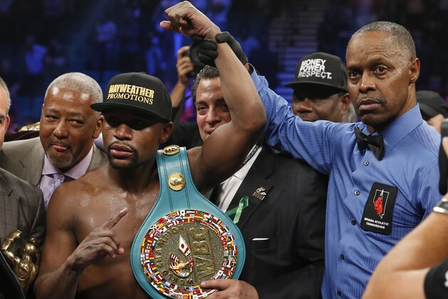 Floyd Mayweather Jr., left, holds up the title belt next to referee Kenny Bayless after his win against Manny Pacquiao, from the Philippines, in their welterweight title fight on Saturday, May 2, 2015 in Las Vegas. (AP Photo/John Locher)