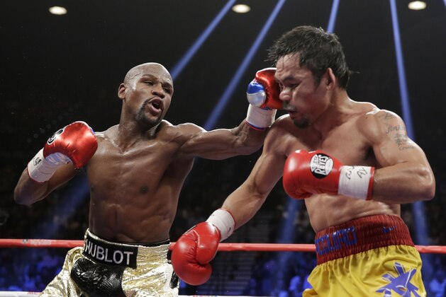 Floyd Mayweather Jr., left, hits Manny Pacquiao, from the Philippines, during their welterweight title fight on Saturday, May 2, 2015 in Las Vegas. (AP Photo/Isaac Brekken)