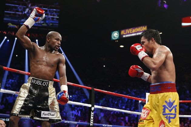 Floyd Mayweather Jr., left, celebrates during his welterweight title fight against Manny Pacquiao, from the Philippines, on Saturday, May 2, 2015 in Las Vegas. (AP Photo/John Locher)