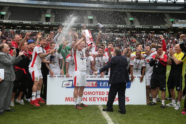 MILTON KEYNES, ENGLAND - MAY 03:  MK Dons players celebrate after gaining promotion to the Championship at the end of the Sky Bet League One match between MK Dons and Yeovil Town at Stadium mk on May 3, 2015 in Milton Keynes, England.  (Photo by Pete Norton/Getty Images)