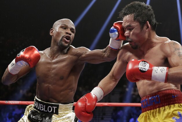 Floyd Mayweather Jr., left, hits Manny Pacquiao, from the Philippines, during their welterweight title fight on Saturday, May 2, 2015 in Las Vegas. (AP Photo/Isaac Brekken)