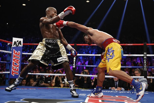 Manny Pacquiao, from the Philippines, right, hits Floyd Mayweather Jr., during their welterweight title fight on Saturday, May 2, 2015 in Las Vegas. (AP Photo/John Locher)