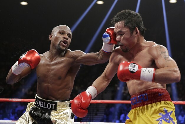 Floyd Mayweather Jr., left, hits Manny Pacquiao, from the Philippines, during their welterweight title fight on Saturday, May 2, 2015 in Las Vegas. (AP Photo/Isaac Brekken)