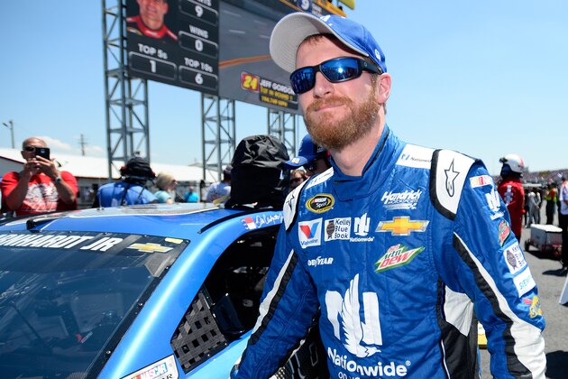 Dale Earnhardt Jr. walks next to his No. 88 Chevrolet during qualifying for the NASCAR Sprint Cup Series auto race at Talladega Superspeedway, Saturday, May 2, 2015, in Talladega, Ala. (AP Photo/David Tulis)