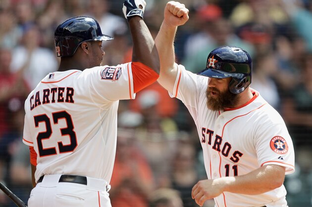 HOUSTON, TX - MAY 03:  Evan Gattis #11 of the Houston Astros receives a high five from Chris Carter #23 after hittinga home run in the eighth inning against the Seattle Mariners at Minute Maid Park on May 3, 2015 in Houston, Texas.  (Photo by Bob Levey/Getty Images)