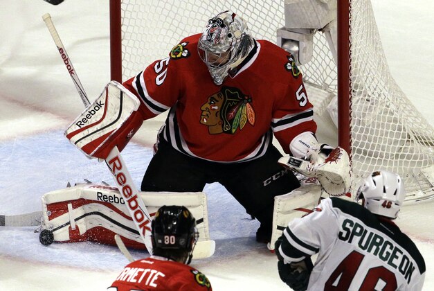 Chicago Blackhawks goalie Corey Crawford (50) blocks a shot by Minnesota Wild defenseman Jared Spurgeon (46) during the third period  of Game 2 in the second round of the NHL Stanley Cup hockey playoffs in Chicago, Sunday, May 3, 2015. The Blackhawks won 4-1. (AP Photo/Nam Y. Huh)