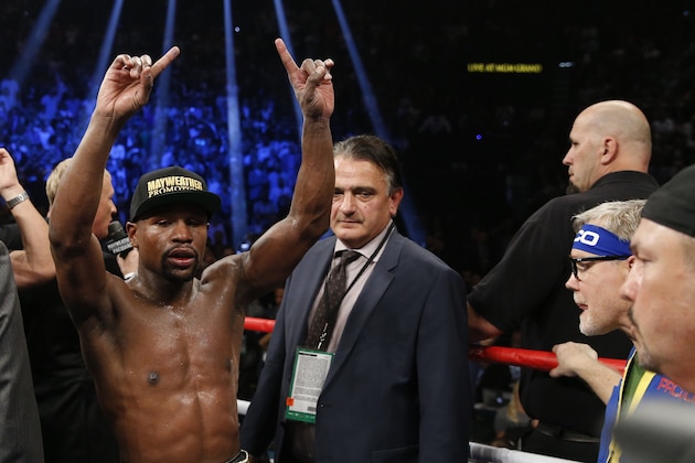 Floyd Mayweather Jr., left, celebrates after his welterweight title fight against Manny Pacquiao, from the Philippines, on Saturday, May 2, 2015 in Las Vegas. (AP Photo/John Locher)