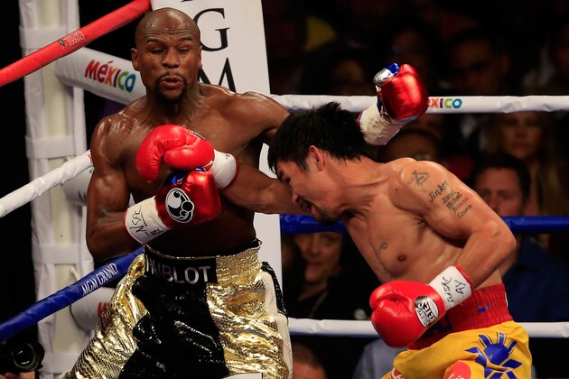 LAS VEGAS, NV - MAY 02:  Manny Pacquiao throws a right at Floyd Mayweather Jr. during their welterweight unification championship bout on May 2, 2015 at MGM Grand Garden Arena in Las Vegas, Nevada.  (Photo by Jamie Squire/Getty Images)