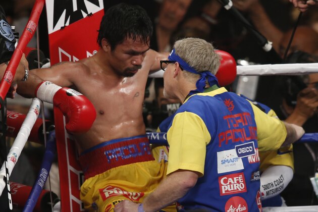 Manny Pacquiao, left, listens to trainer Freddie Roach between rounds of his welterweight title fight against Floyd Mayweather Jr. on Saturday, May 2, 2015 in Las Vegas. (AP Photo/Eric Jamison)