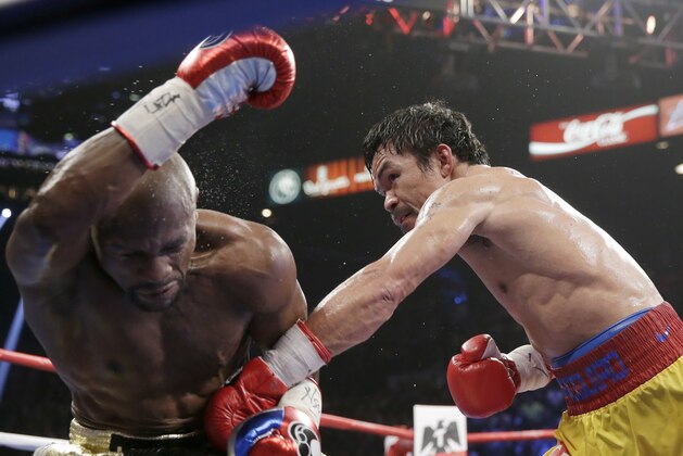 Manny Pacquiao (derecha) logra embestir a Floyd Mayweather Jr. en la pelea por el título welter, el sábado 2 de mayo de 2015. (AP Foto/Isaac Brekken)