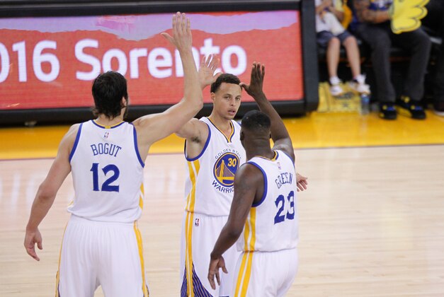 May 3, 2015; Oakland, CA, USA; Golden State Warriors guard Stephen Curry (30) congratulates center Andrew Bogut (12) and forward Draymond Green (23) during a timeout against the Memphis Grizzlies during the third quarter in game one of the second round of the NBA Playoffs at Oracle Arena. The Warriors defeated the Grizzlies 101-86. Mandatory Credit: Cary Edmondson-USA TODAY Sports