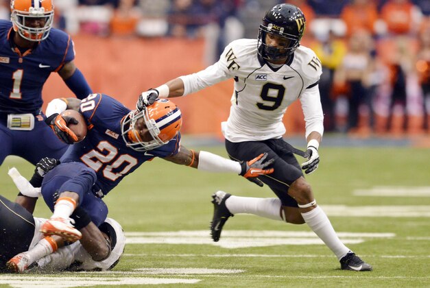 Nov 2, 2013; Syracuse, NY, USA; Wake Forest Demon Deacons cornerback Kevin Johnson (9) grabs the helmet of Syracuse Orange wide receiver Brisly Estime (20) on a tackle during the second quarter of a game at the Carrier Dome. Mandatory Credit: Mark Konezny-USA TODAY Sports
