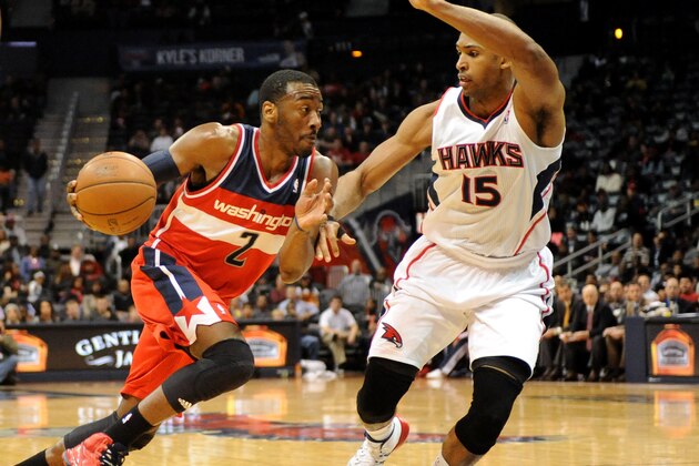 Washington Wizards guard John Wall (2) controls the ball in front of Atlanta Hawks center Al Horford (15) in the second half of their NBA basketball game on Friday, Dec. 13, 2013, in Atlanta. Atlanta won 101-99 in overtime. (AP Photo/David Tulis)