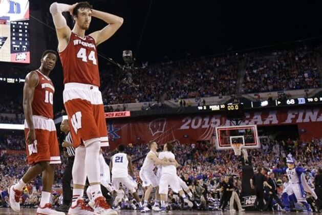 Wisconsin's Frank Kaminsky (44) and Nigel Hayes (10) walk off the court as Duke players celebrate their 68-63 victory over Wisconsin in the NCAA Final Four college basketball tournament championship game Monday, April 6, 2015, in Indianapolis.  (AP Photo/Michael Conroy)