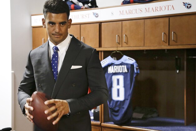 Marcus Mariota, former Oregon quarterback and overall No. 2 NFL football draft pick by the Tennessee Titans, poses for photos in the locker room Friday, May 1, 2015, in Nashville, Tenn. Mariota was selected by the Titans in the first round Thursday. (AP Photo/Mark Humphrey)