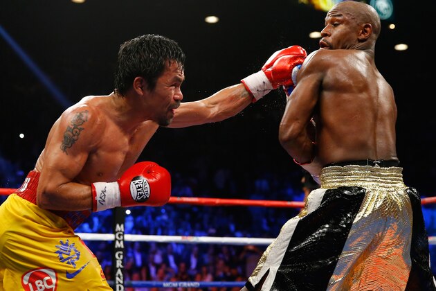 LAS VEGAS, NV - MAY 02:  Manny Pacquiao throws a left at Floyd Mayweather Jr. during their welterweight unification championship bout on May 2, 2015 at MGM Grand Garden Arena in Las Vegas, Nevada.  (Photo by Al Bello/Getty Images)