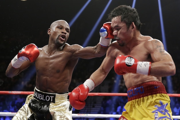 Floyd Mayweather Jr., left, hits Manny Pacquiao, from the Philippines, during their welterweight title fight on Saturday, May 2, 2015 in Las Vegas. (AP Photo/Isaac Brekken)