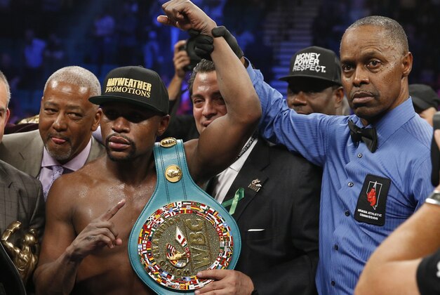 Floyd Mayweather Jr., left, holds up the title belt next to referee Kenny Bayless after his win against Manny Pacquiao, from the Philippines, in their welterweight title fight on Saturday, May 2, 2015 in Las Vegas. (AP Photo/John Locher)