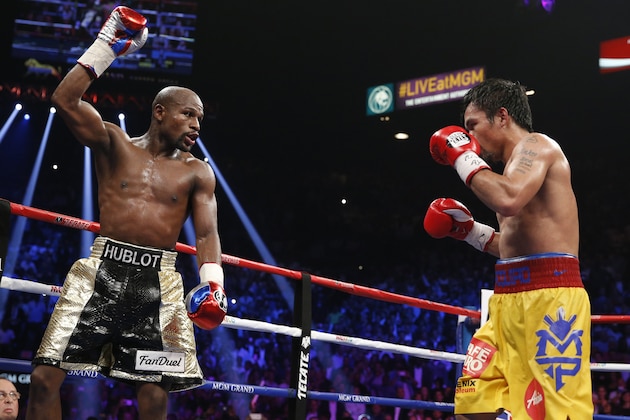 Floyd Mayweather Jr., left, celebrates during his welterweight title fight against Manny Pacquiao, from the Philippines, on Saturday, May 2, 2015 in Las Vegas. (AP Photo/John Locher)