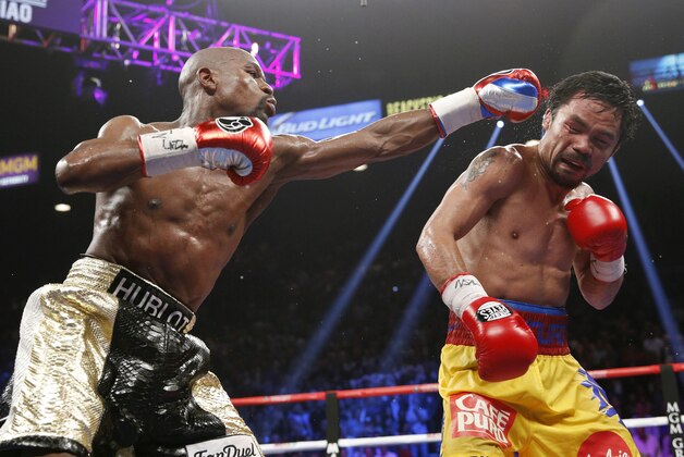 FILE - In this May 2, 2015 file photo, Floyd Mayweather Jr., left, hits Manny Pacquiao, from the Philippines, during their welterweight title fight in Las Vegas. The broadcast of fight was marred by technical snafus and got sucker punched by Internet streamers, exposing the industry’s vulnerabilities. (AP Photo/John Locher, File)