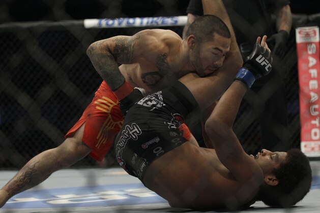 Damacio Page, top, fights Alex Caceres during a UFC on Fuel 4 Mixed Martial Arts bantamweight bout in San Jose, Calif., Wednesday, July 11, 2012. (AP Photo/Jeff Chiu)