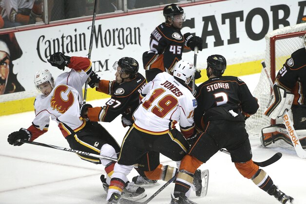 Anaheim Ducks' Rickard Rakell(67), of Sweden, shoves Calgary Flames' Mason Raymond(21) as Ducks' Clayton Stoner(3) and Flames' David Jones fight for the puck during the first period of Game 2 in the second round of the NHL Stanley Cup hockey playoffs, Sunday, May 3, 2015, in Anaheim, Calif. (AP Photo/Jae C. Hong)