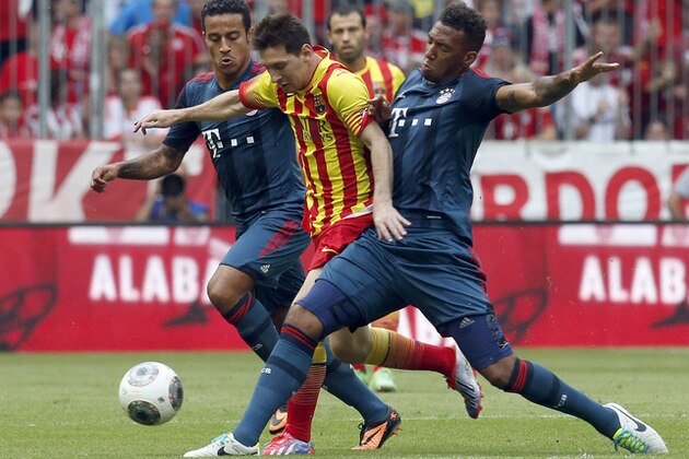 Barcelona's Messi, center, Munich's Thiago, left, and Munich's Jerome Boateng challenge for the ball during their friendly soccer match in the Allianz Arena stadium in Munich, southern Germany, on Wednesday, July 24, 2013. (AP Photo/Matthias Schrader)