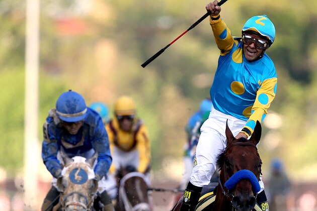 LOUISVILLE, KY - MAY 02:  Jockey Victor Espinoza celebrates as he guides American Pharoah #18 after crossing the finish line to win the 141st running of the Kentucky Derby at Churchill Downs on May 2, 2015 in Louisville, Kentucky.  (Photo by Chris Graythen/Getty Images)