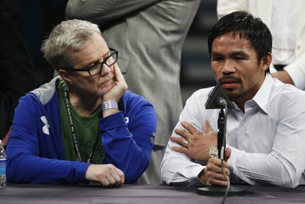 FILE - In this May 2, 2015 photo, trainer Freddie Roach, left, listens as Manny Pacquiao answers questions during a press conference following his welterweight title fight against Floyd Mayweather Jr. in Las Vegas. Pacquiao could face disciplinary action from Nevada boxing officials for failing to disclose a shoulder injury before the fight. Nevada Athletic Commission Chairman Francisco Aguilar said that the state attorney general’s office will look at why Pacquiao checked “no” a day before the fight on a commission questionnaire asking if he had a shoulder injury. (AP Photo/John Locher)