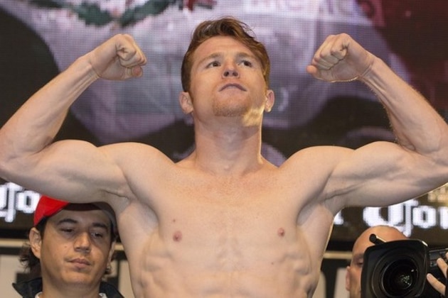 Canelo Alvarez poses for photos on the scale during the weigh-in for his Saturday boxing bout against Floyd Mayweather Jr., Friday, Sept. 13, 2013, in Las Vegas. (AP Photo/Julie Jacobson)