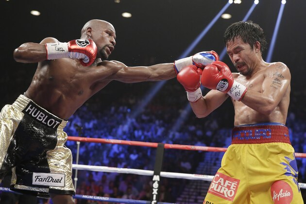 Floyd Mayweather Jr., left, stops Manny Pacquiao, from the Philippines, with a left during their welterweight title fight on Saturday, May 2, 2015 in Las Vegas. (AP Photo/Isaac Brekken)