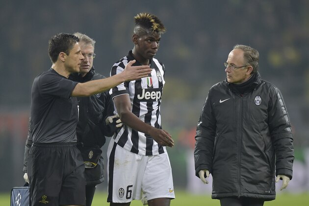 Referee Milorad Mazic, left, indicates Juventus' Paul Pogba, center, to leave the pitch after suffering an injury during the Champions League round of 16 second leg soccer match between Borussia Dortmund and Juventus Turin on Wednesday, March 18, 2015 in Dortmund, Germany. (AP Photo/Martin Meissner)