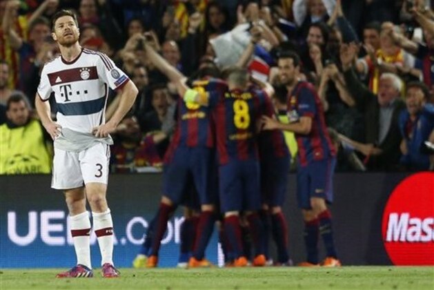 Bayern's Xabi Alonso reacts as Barcelona celebrate after scoring the opening goal during the Champions League semifinal first leg soccer match between Barcelona and Bayern Munich at the Camp Nou stadium in Barcelona, Spain, Wednesday, May 6, 2015.  (AP Photo/Manu Fernandez)