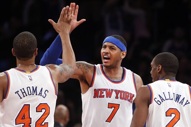 New York Knicks' Carmelo Anthony (7) celebrates with teammates Lance Thomas (42) and Langston Galloway (2) after a 3-point basket by Galloway against the Orlando Magic during the fourth quarter of an NBA basketball game Friday, Jan. 23, 2015, in New York. New York won 113-106. (AP Photo/Jason DeCrow)