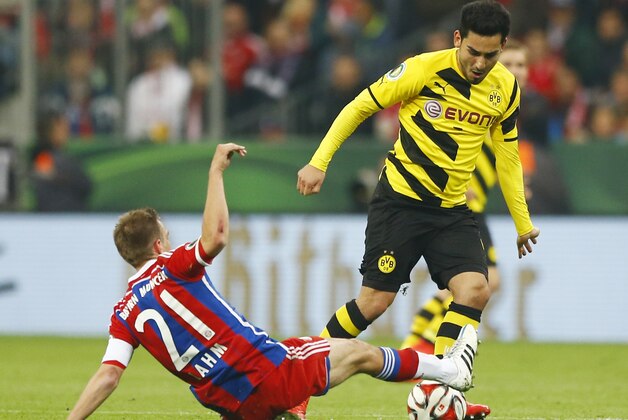 Bayern's Philipp Lahm, left, and Dortmund's Ilkay Gundogan challenge for the ball during the German soccer cup (DFB Pokal) semifinal match between FC Bayern Munich and Borussia Dortmund at the Allianz Arena in Munich, Germany, on Tuesday, April 28, 2015. (AP Photo/Matthias Schrader)