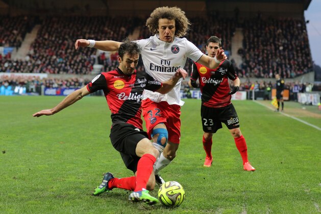 Paris Saint Germain's defender David Luiz of Brazil challenges for the ball with Guingamp's french defender Christophe Kerbrat during their League One soccer match, in Guingamp, western France, Sunday, Dec. 14 , 2014. (AP Photo/David Vincent)