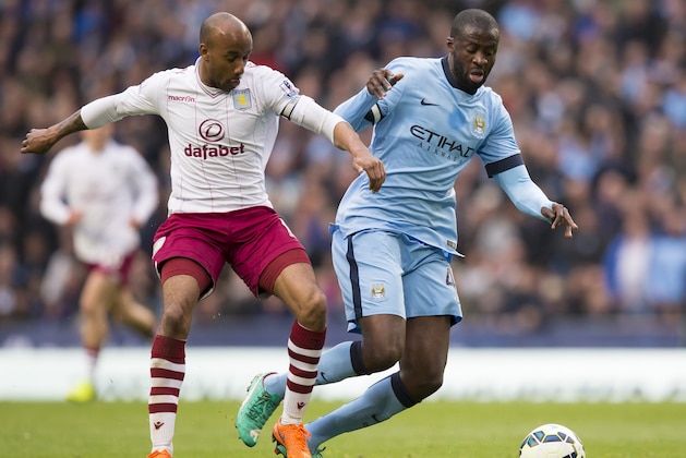 Manchester City's Yaya Toure, right, fights for the ball against Aston Villa's Fabian Delph during the English Premier League soccer match between Manchester City and Aston Villa at the Etihad Stadium, Manchester, England, Saturday April 25, 2015. (AP Photo/Jon Super)