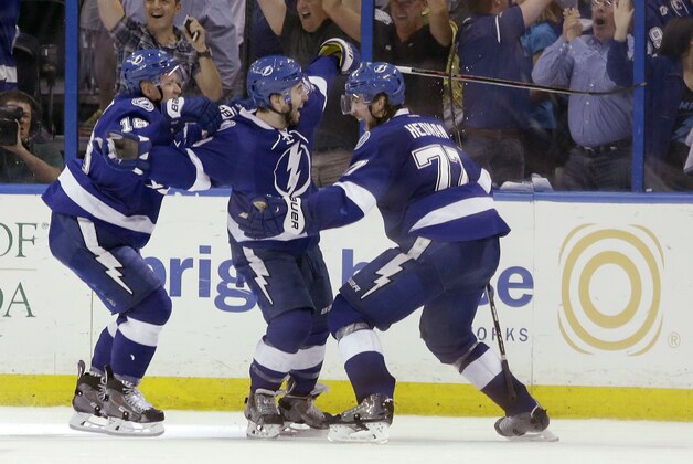 Tampa Bay Lightning defenseman Victor Hedman of Sweden, right, and left wing Ondrej Palat of the Czech Republic, left, celebrate with center Tyler Johnson, center, after Johnson scored the winning goal at the end of the third period of Game 3 NHL second round playoff hockey match against the Montreal Canadiens, Wednesday, May 6, 2015, in Tampa, Fla. The Lightning defeated the Canadiens 2-1. (AP Photo/Wilfredo Lee)