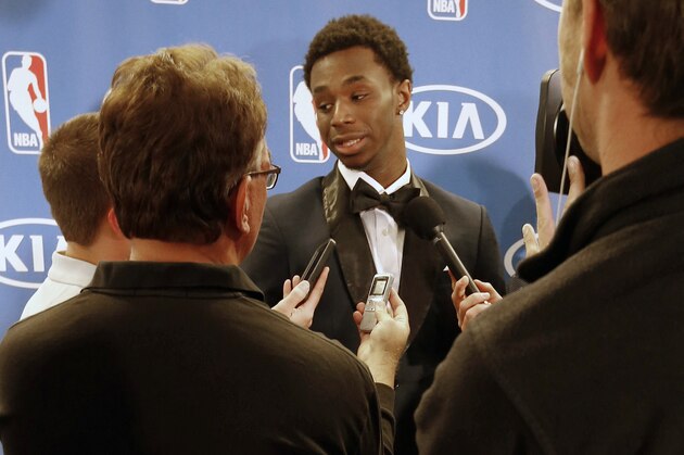 His trophy stands in the foreground as Minnesota Timberwolves' Andrew Wiggins, top center, talks to reporters after a news conference where he was introduced as NBA basketball Rookie of the Year, Thursday, April 30, 2015, in Minneapolis. (AP Photo/Jim Mone)